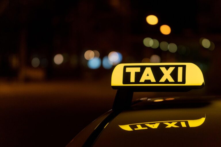 Picture of a taxi sign on top of a taxi